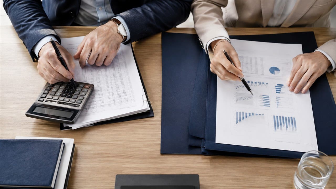 comptable-expert-fiscal-A Un comptable et un expert fiscal examinent des comptes et un plan financier.
